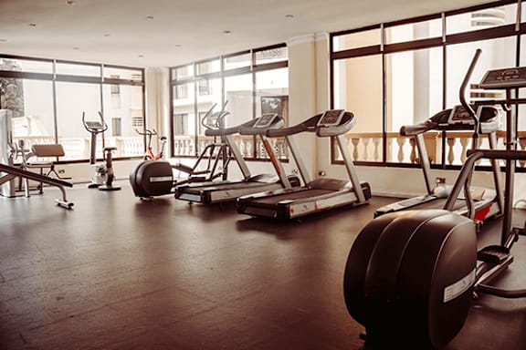 A gym with treadmills, exercise bikes, and weight machines.
