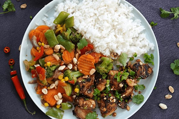 A plate of food with rice, vegetables, and meat.