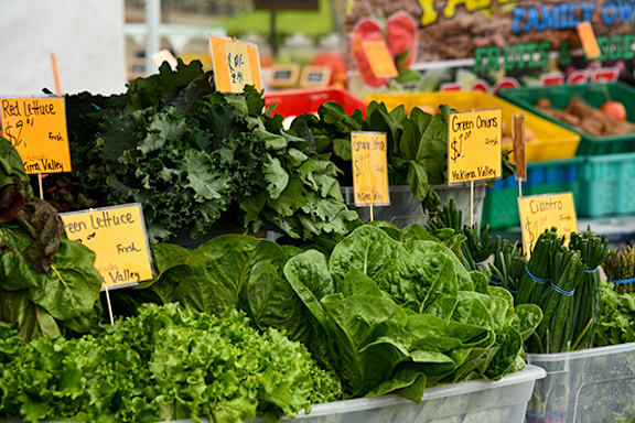 A bunch of green lettuce is for sale at a market.