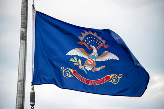 The flag of South Dakota is blue with a white eagle and a banner that reads "Lakota and Dakota".
