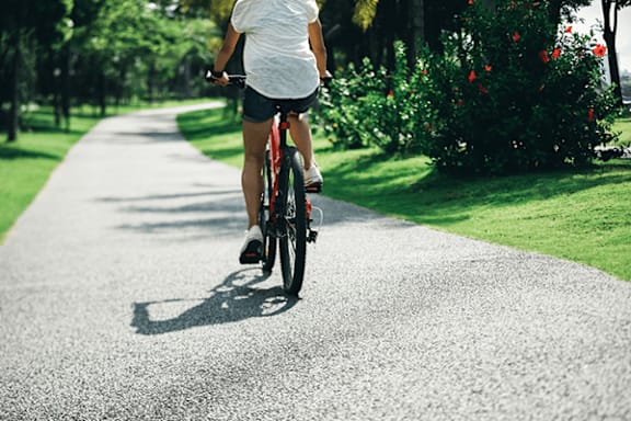 A person riding a bicycle on a paved path.