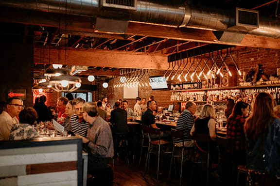 A group of people are sitting at tables in a restaurant.