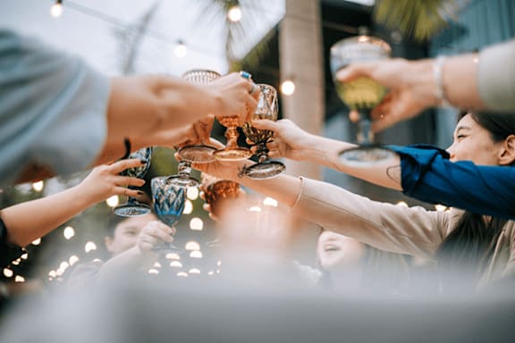 A group of people clinking glasses together in a celebratory toast.