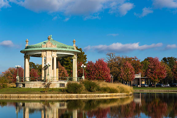 A gazebo sits in the middle of a lake surrounded by trees.