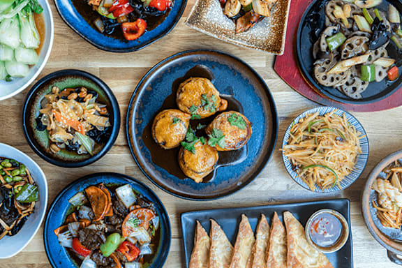 A variety of dishes are served on blue plates.