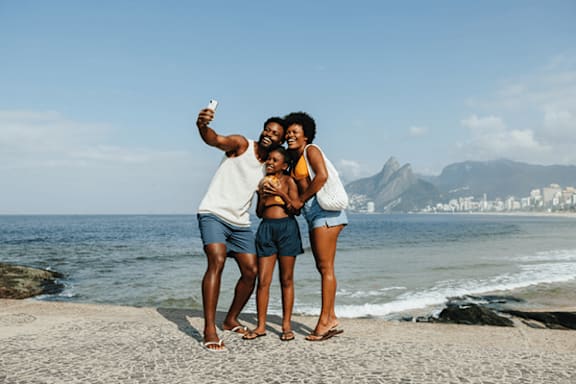 Three people taking a selfie on a beach.
