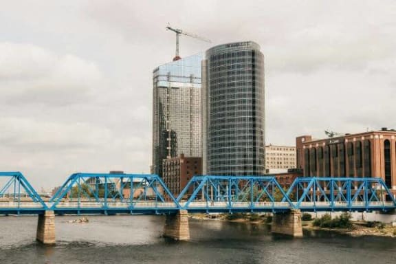 a blue bridge over a body of water with a building