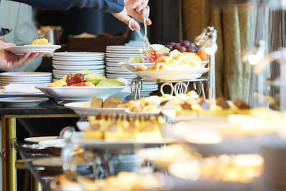 A person is serving food from a tray.
