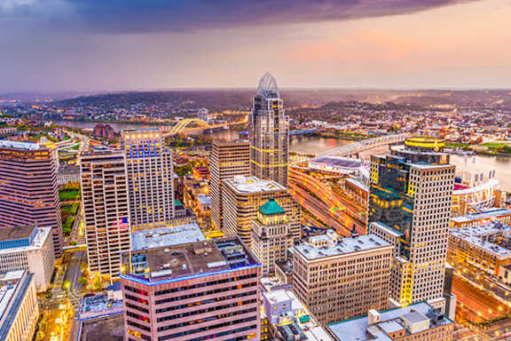 A cityscape with a mix of modern and older buildings, with a prominent skyscraper in the center.