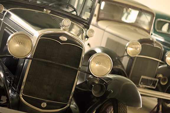 A close up of a vintage car's grill and headlights.