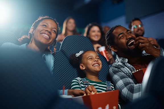 A group of people are watching a movie in a theater.