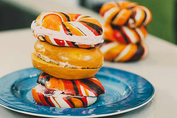 A stack of colorful striped donuts on a blue plate.