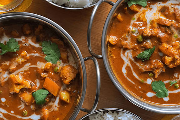 A dish of curry with chicken and vegetables.
