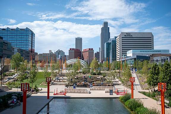 A cityscape with a large body of water in the foreground and a variety of buildings in the background.