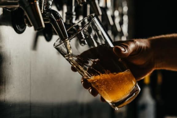 a person pouring a beer into a glass