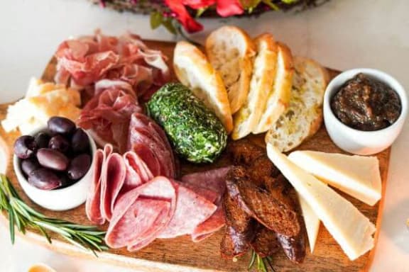 a platter of meats and cheese on a cutting board