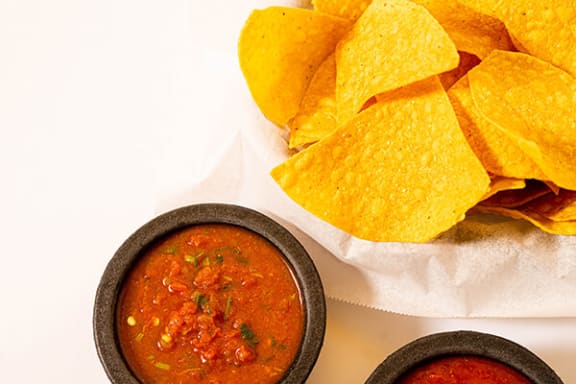 a plate of chips and a bowl of salsa