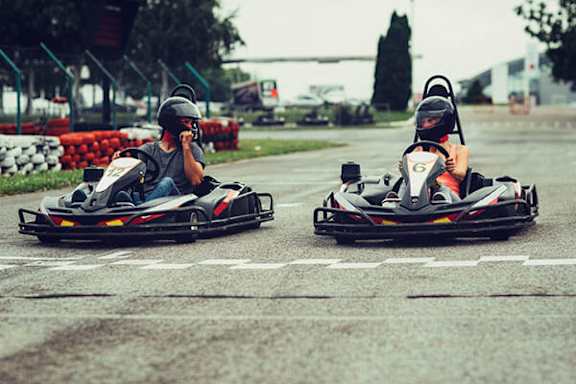 Two people are karting on a track.