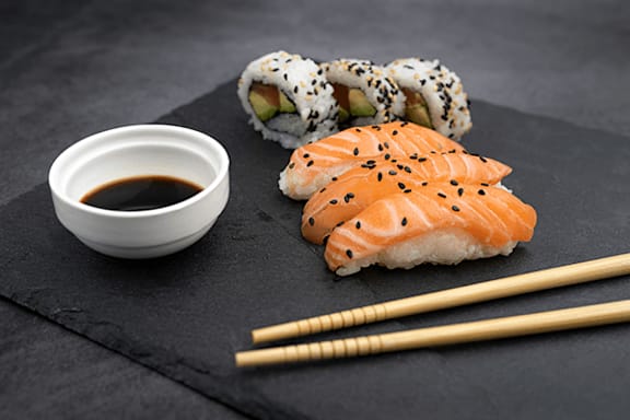A sushi set with soy sauce and chopsticks.