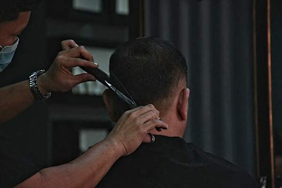 A man getting his hair cut by a barber.