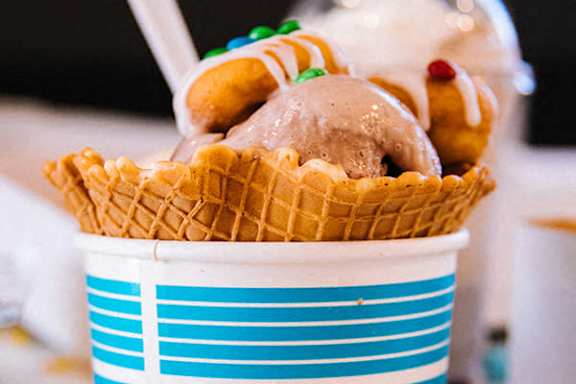 A cup of ice cream with a waffle cone.