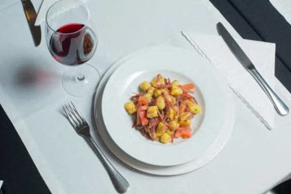 a plate of food on a table with a glass of wine