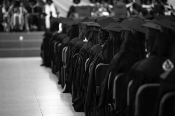 a black and white photo of graduates in their caps and gowns