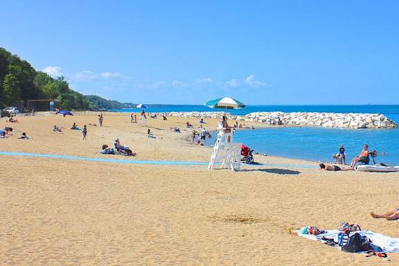 A beach scene with people sunbathing and relaxing.