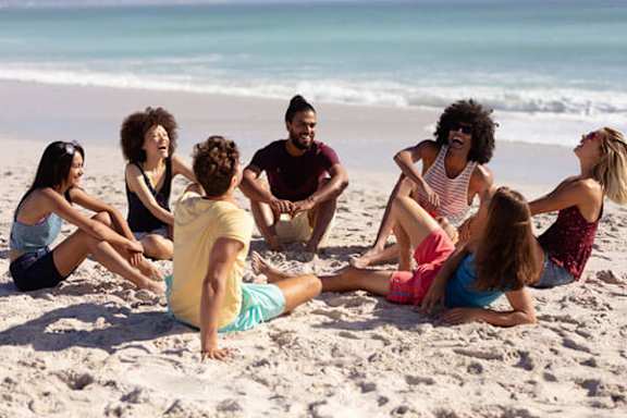 A group of people sitting on a beach.