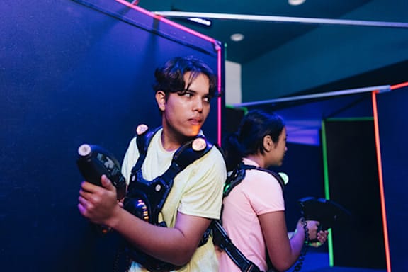 Two people playing a video game with guns.