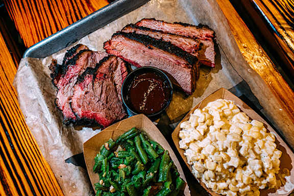A tray of food including steak, beans and popcorn.