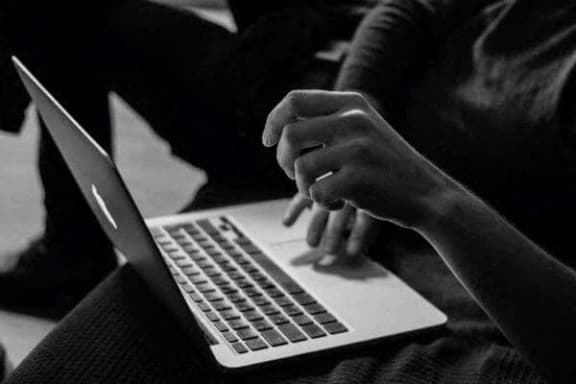 a person using a laptop computer on their lap