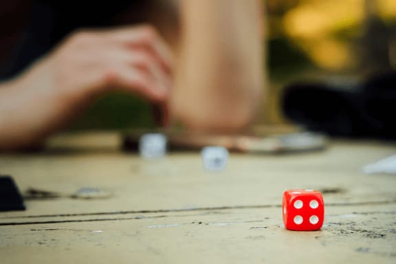 a red dice on a wooden table