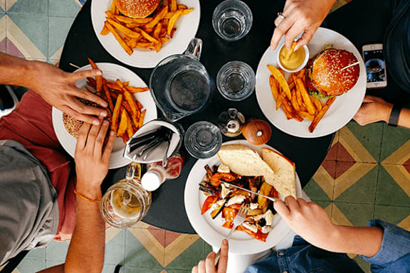 A top view of a group of people sharing a meal with burgers and fries.