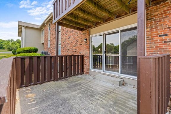 a porch of a brick house with a wooden deck