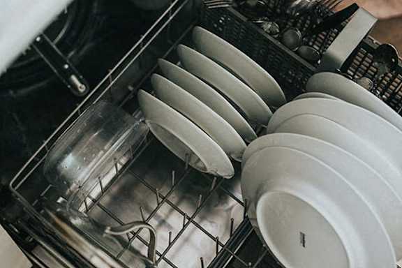 Plates are stacked in a dishwasher.