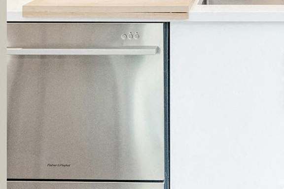 A Fisher & Paykel stainless steel oven is built into a kitchen counter.