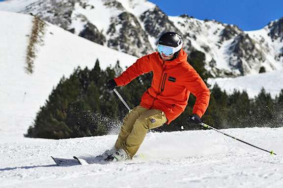 A skier in an orange jacket is skiing down a snowy mountain.