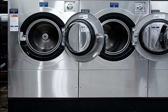 Three washing machines are lined up next to each other.