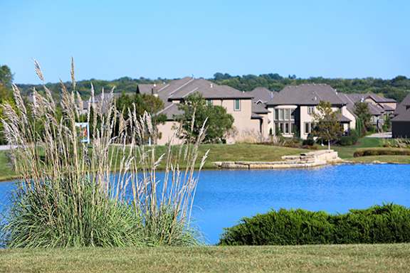 Two flags, one of the United States and one of Kansas, are flying side by side.
