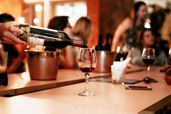 A bottle of wine is being poured into a glass.