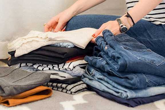 A person is folding a pair of jeans.
