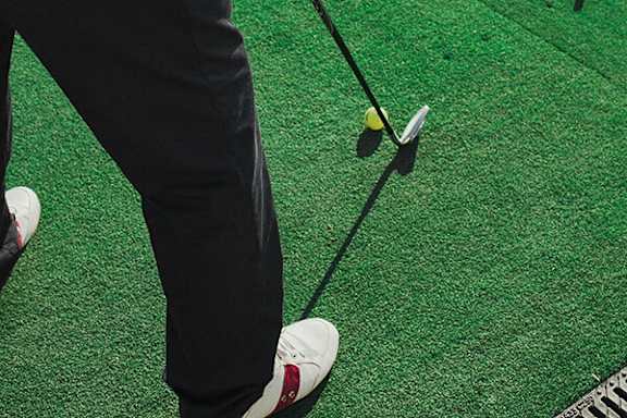 A person is about to hit a golf ball with a club.