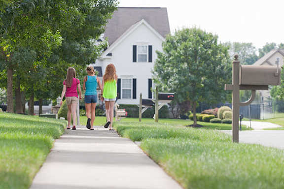 Three women walking down a sidewalk.