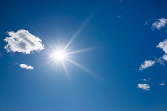 The sun is shining brightly in the clear blue sky.