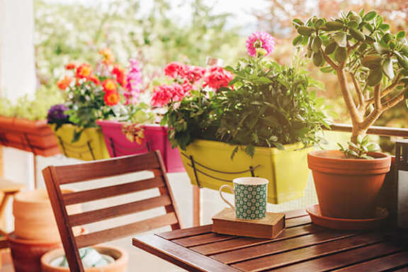 A wooden chair sits on a table with a cup on it.