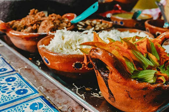 A clay pot filled with food on a table.