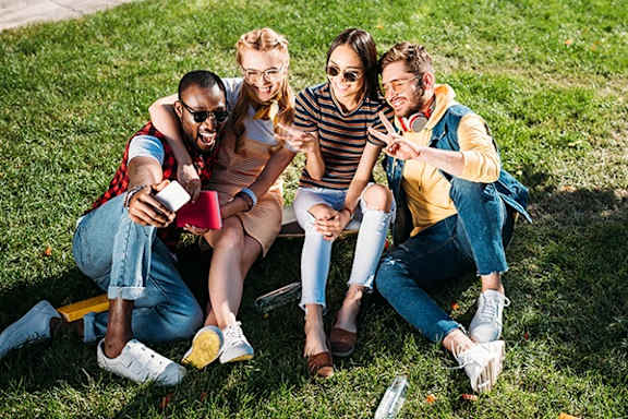 Four friends sitting on the grass.