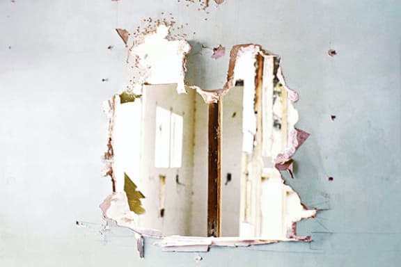 a window in a wall with peeling paint
