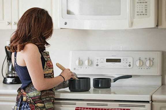 A woman is cooking in a kitchen.